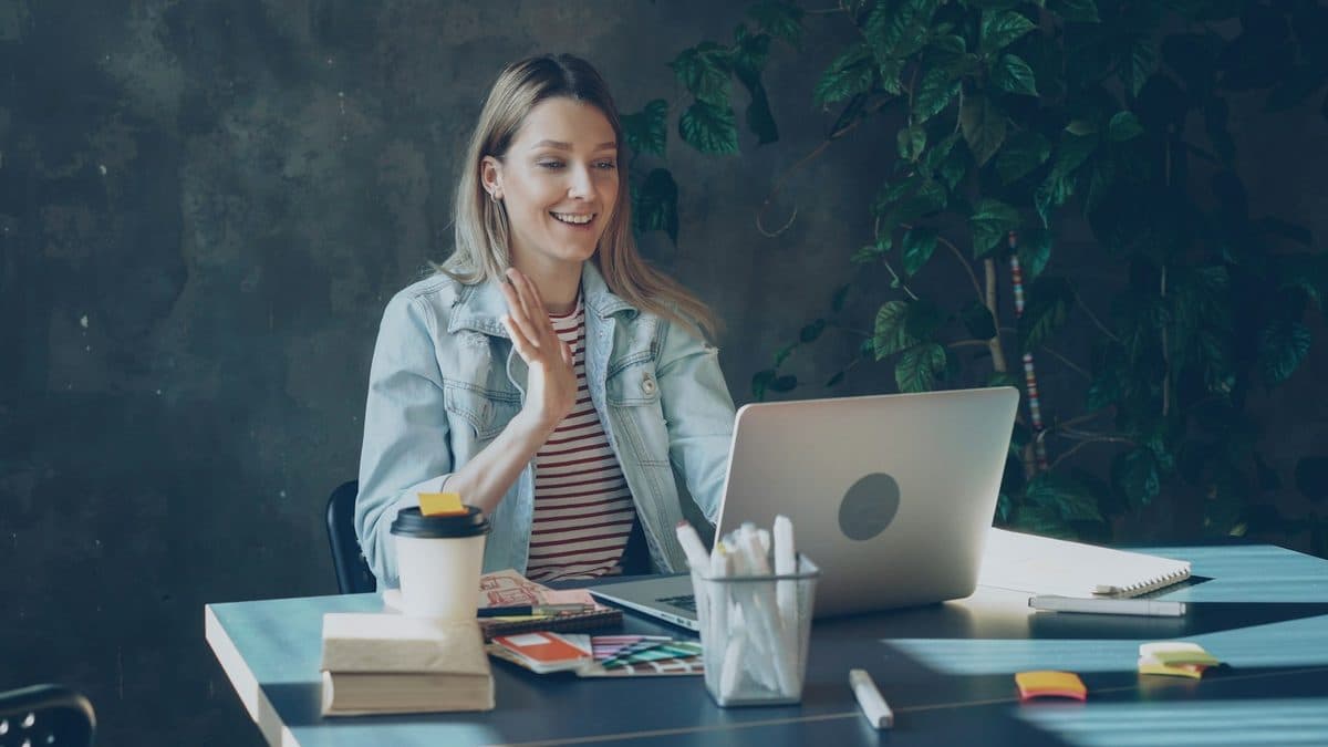 A practitioner waving hello to a client on a video call